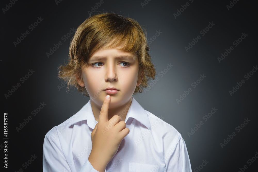 doubt, expression and people concept - boy thinking over gray background doubt, expression and people concept - boy thinking over gray background