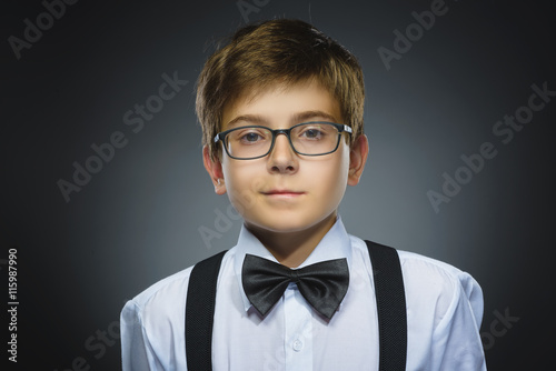 Happy child. Closeup Portrait of handsome boy smiling isolated on grey background