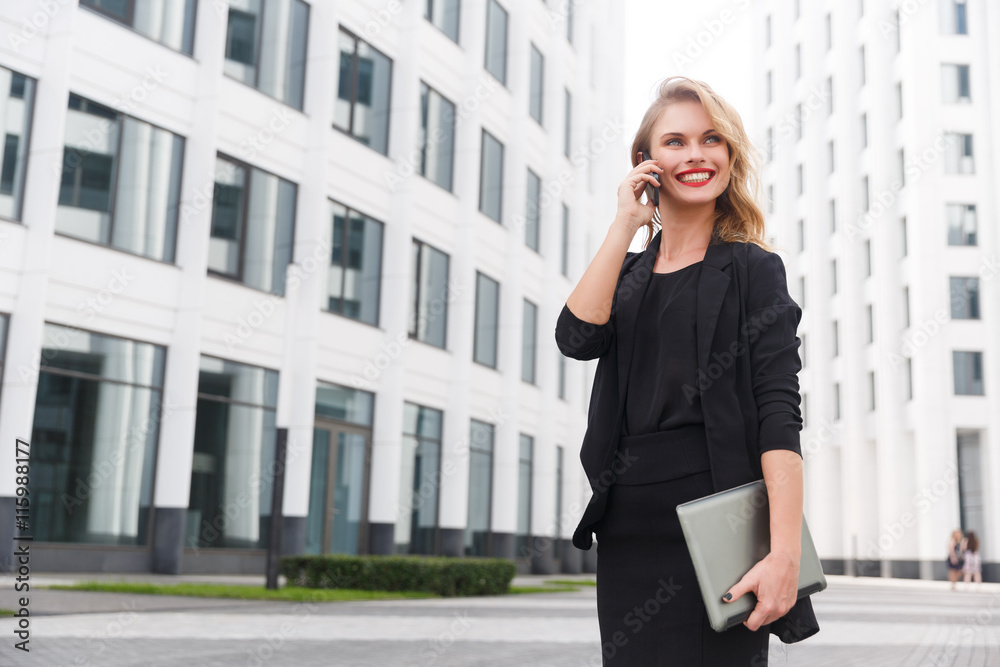 Portrait of smiling blond woman with notebook and smartphone Portrait of smiling blond woman with notebook and smartphone