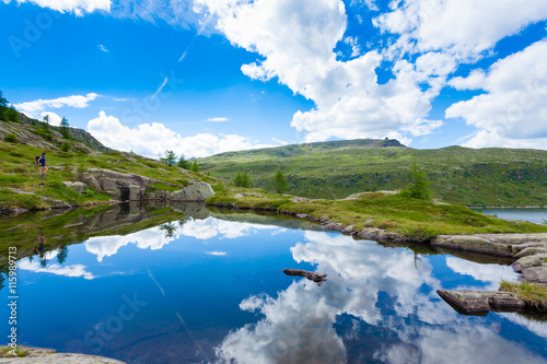 Italian mountain panorama, clouds reflected on alpine lake