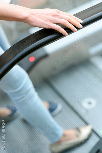 Two women using escalator for movement