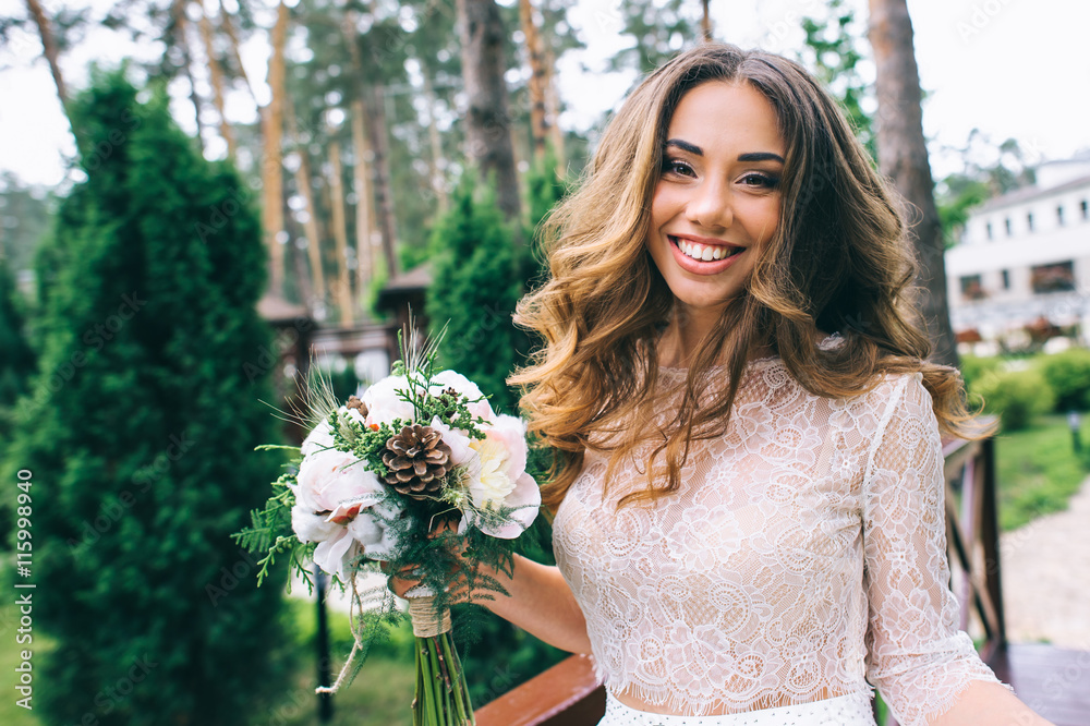beautiful bride with white bouquet in park