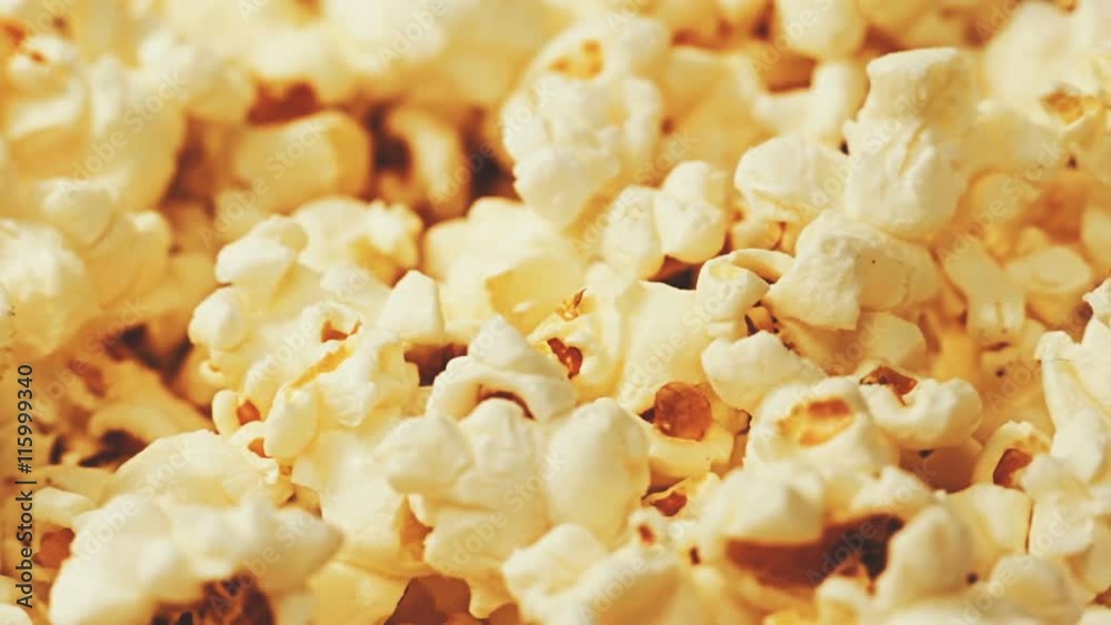 Popcorn background. Close-up panning view of the surface of a large bucket fulled up with popcorn. Popcorn background. Close-up panning view of the surface of a large bucket fulled up with popcorn.