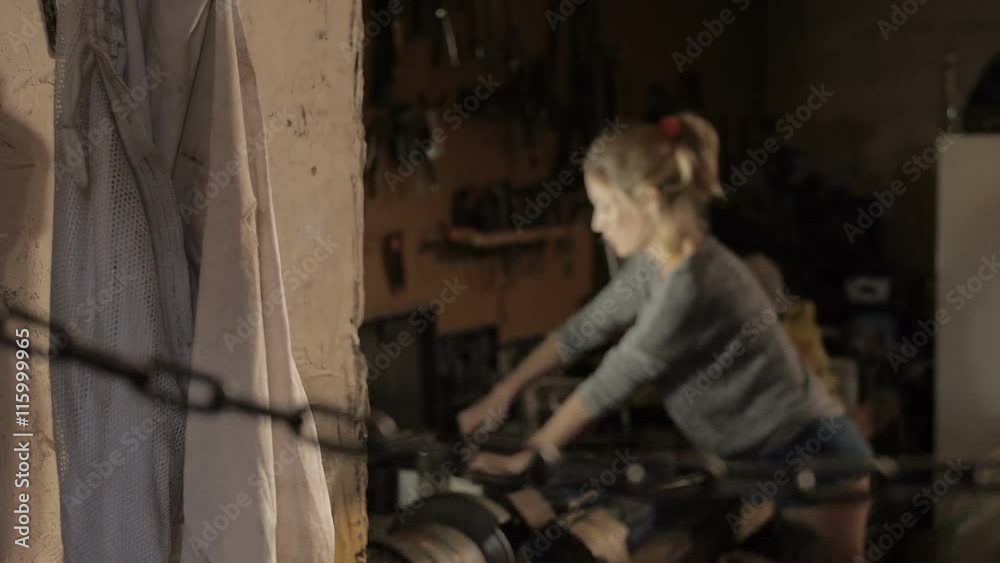 Young woman working as mechanic in garage with tools Young woman working as mechanic in garage with tools