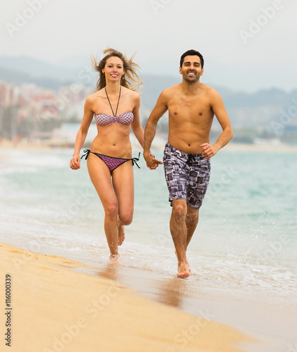 People running in swimwear on the sea waves