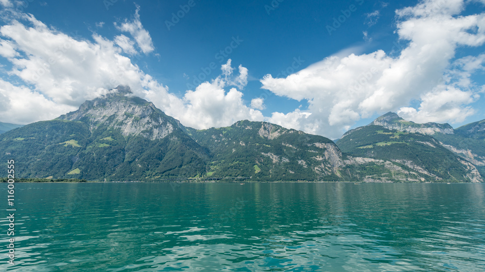 Wide landscape. Mountains and the lake. Clouds in the clear sky.
