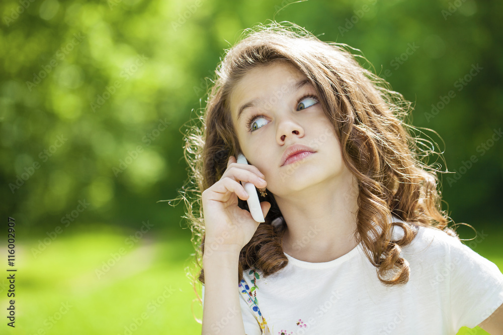 Portrait of a beautiful young little girl calling by phone