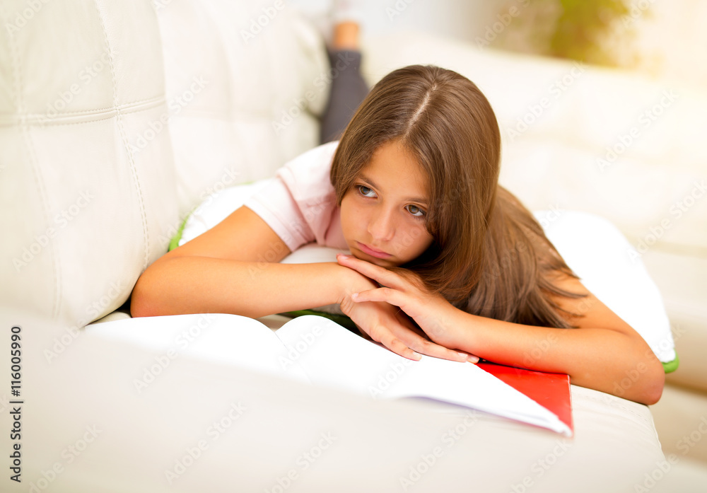 Girl writing in a notebook lying on the bed