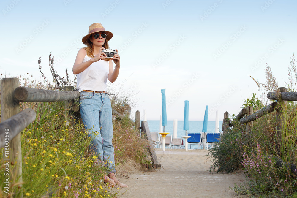 Taking pictures of everything on vacation. Beautiful  woman relaxing at seaside.