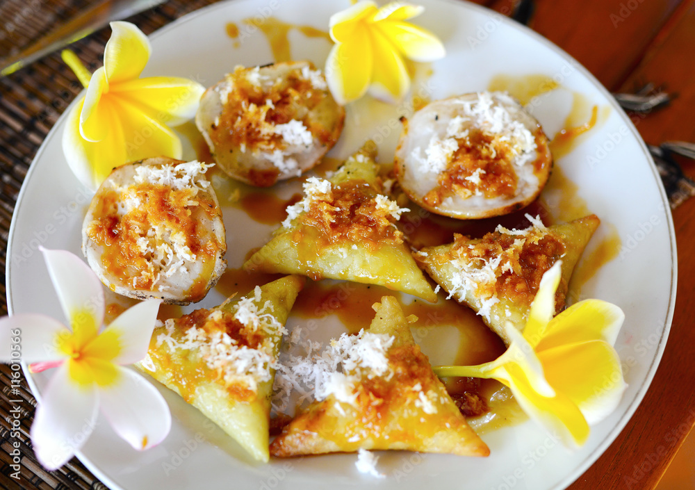 Traditional Balinese breakfast. Rice triangle pancake with coconut and banana Traditional Balinese breakfast. Rice triangle pancake with coconut and banana