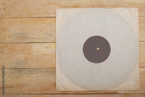 Retro styled image of a collection of old vinyl record lp's with sleeves on a wooden background. Copy space. Top view
