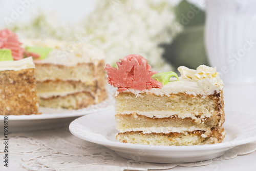 Creamy cake on plate on table on light background