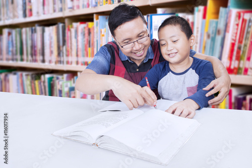 Little boy studying with his teacher
