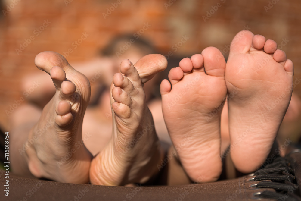Two pairs of childrens feet. Photo closeup Two pairs of childrens feet. Photo closeup