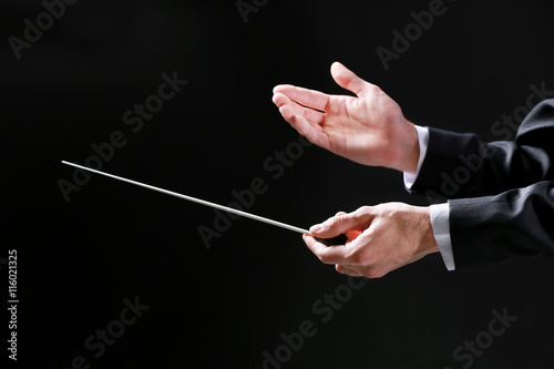 Orchestra conductor hands on black background