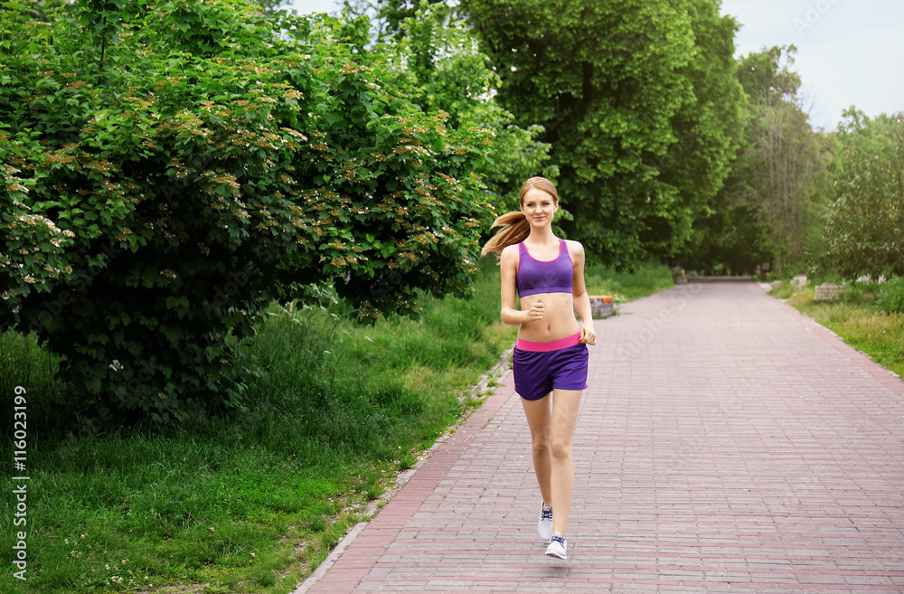 Sporty woman jogging at park on a sunny day