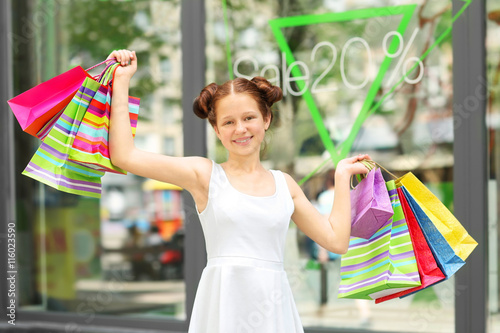 Beautiful girl with shopping bags on street