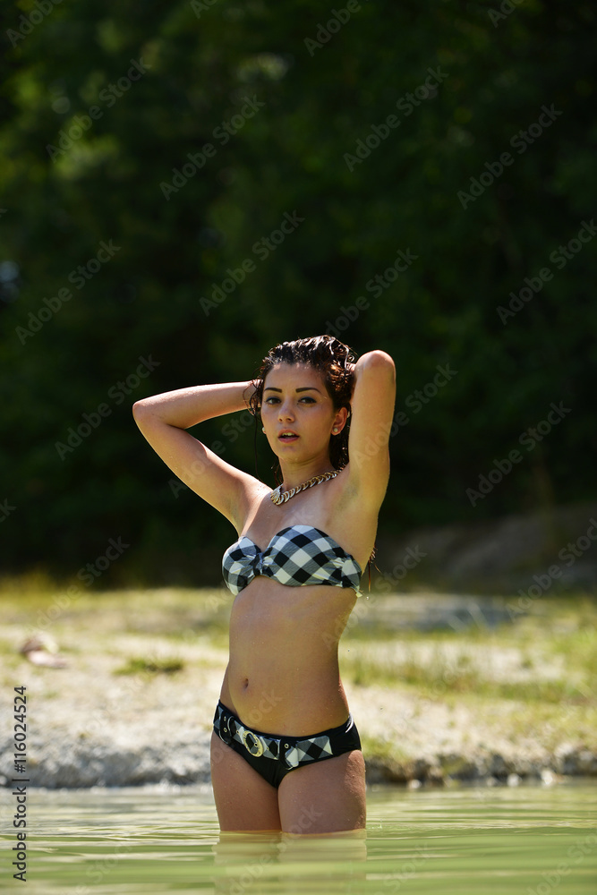 Belle femme en bikini se bronzer au bord de la mer