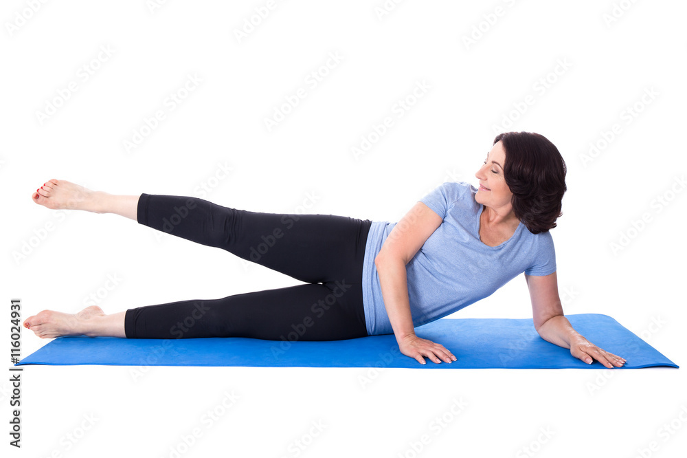 happy mature woman doing exercises on yoga mat isolated on white happy mature woman doing exercises on yoga mat isolated on white