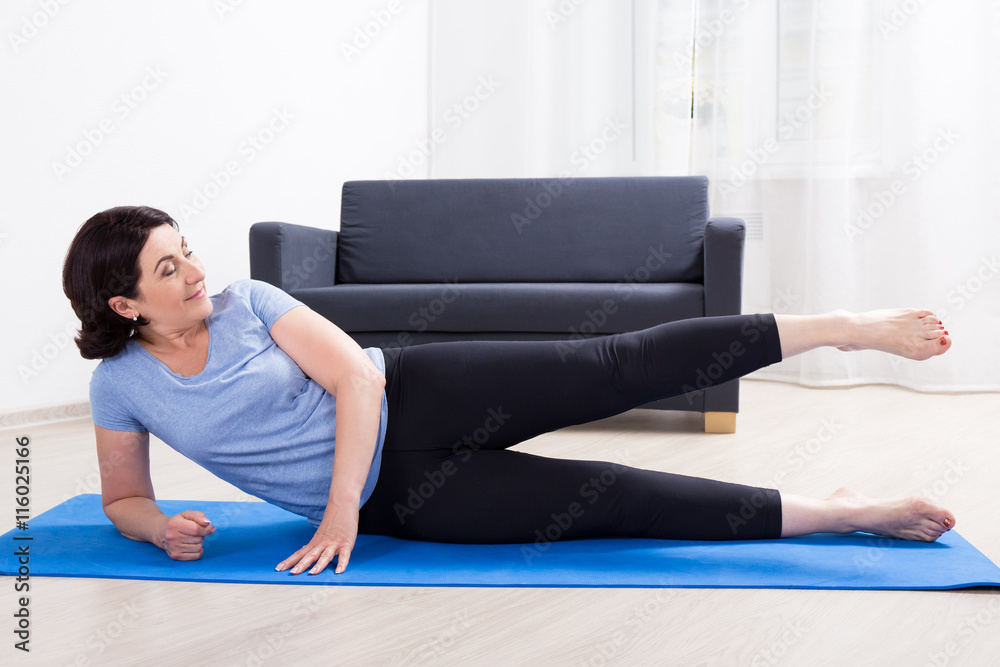 slim sporty mature woman doing stretching exercises on yoga mat slim sporty mature woman doing stretching exercises on yoga mat
