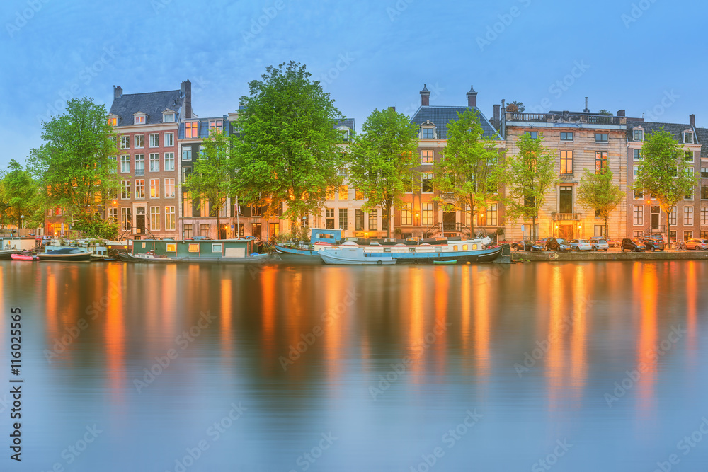 Fototapeta premium Panoramic view and cityscape of Amsterdam with boats, old buildings and Amstel river, Holland, Netherlands