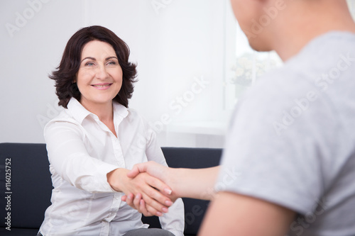 businessman and businesswoman shaking hands in office