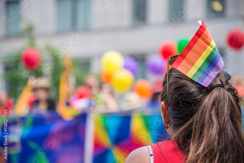Photography A female spectator with a rainbow flag hair stick is watching th