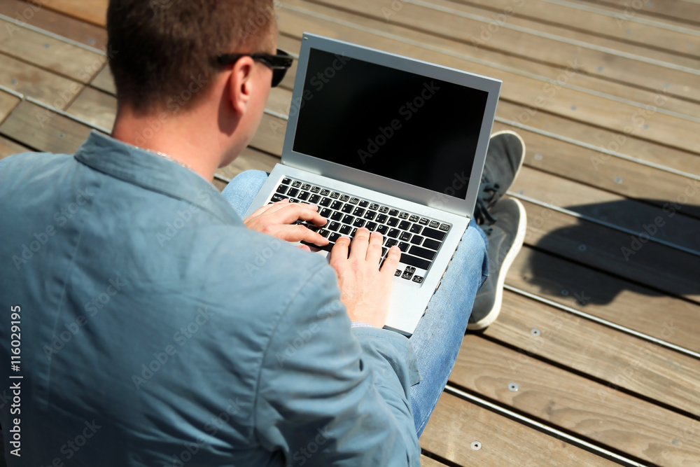 businessman working with a laptop, sitting outside businessman working with a laptop, sitting outside