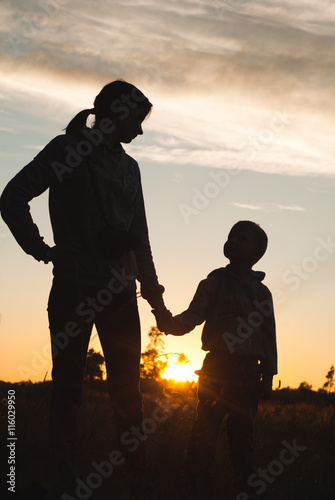 Silhouette of mother and baby at sunset,