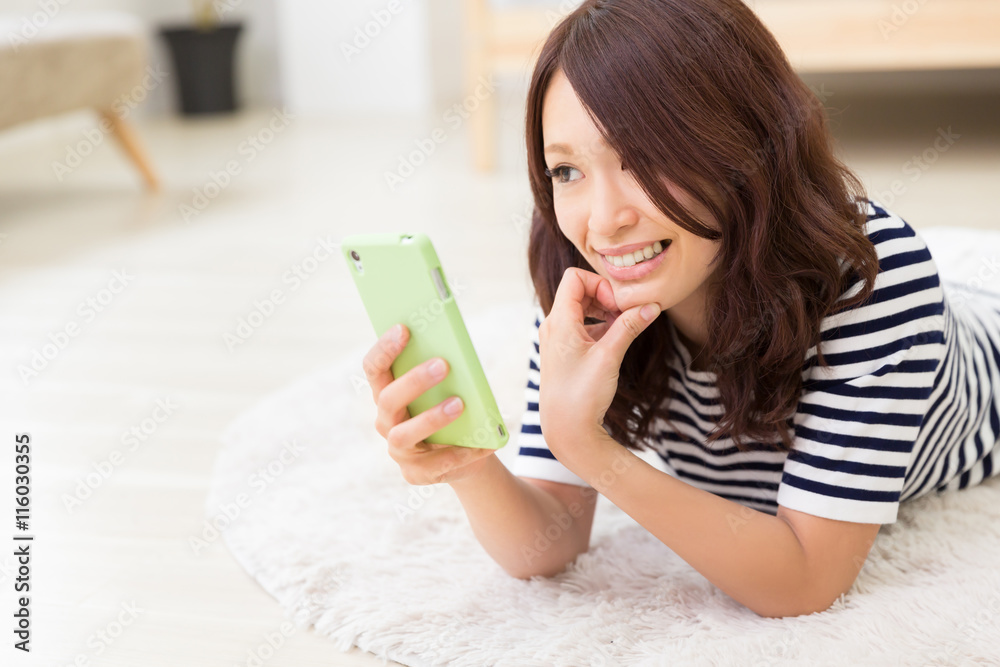 部屋でスマホを見る女性 部屋でスマホを見る女性