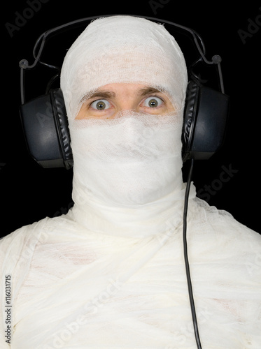 Man in bandage with ear-phones photo