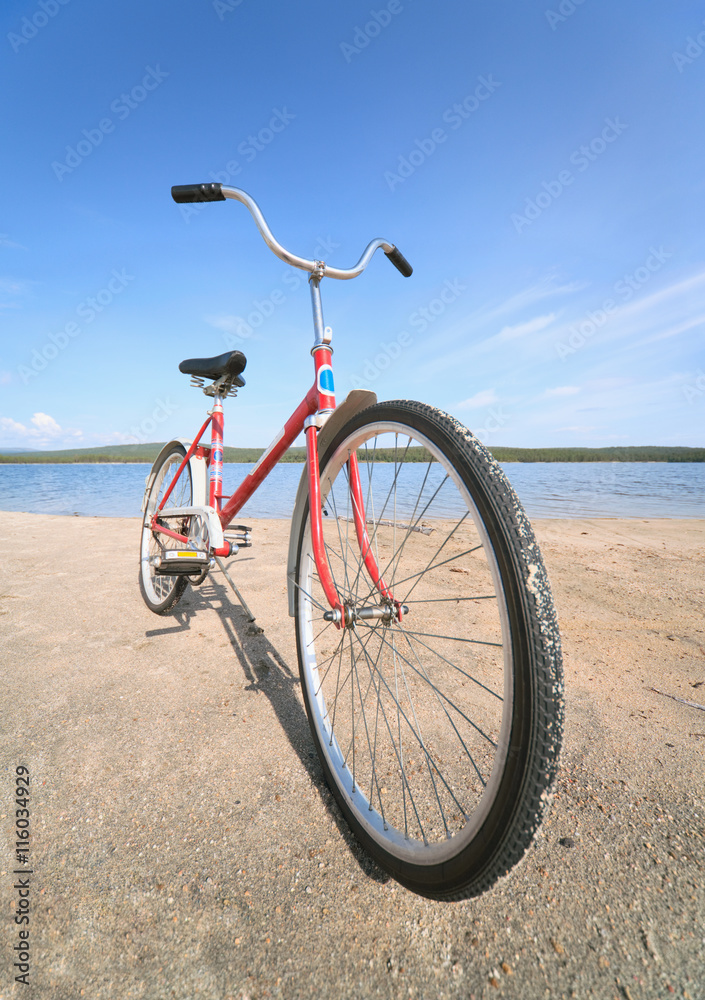 Fototapeta premium Old red bicycle photographed on beach