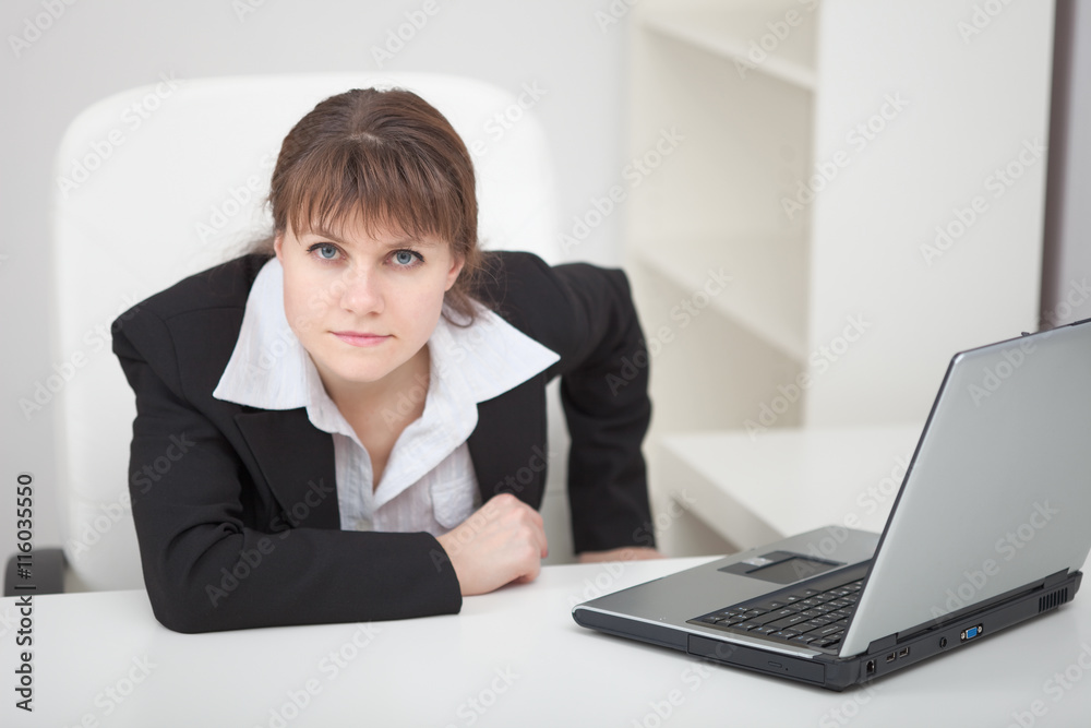 Resolutely woman - managing director sits at table with laptop Resolutely woman - managing director sits at table with laptop