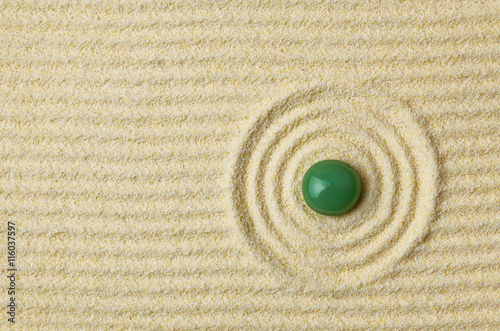 Photography Green stone on surface of yellow sand