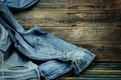 bunch of jeans on a wooden background strewn, fashionable clothes