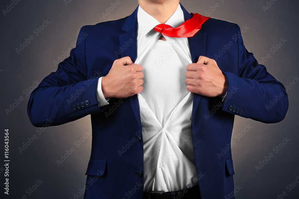 Young businessman super hero on dark background Young businessman super hero on dark background