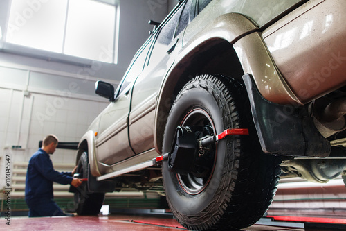 Auto wheel alignment in auto service, SUV maintenance. Car preparing for professional diagnostics