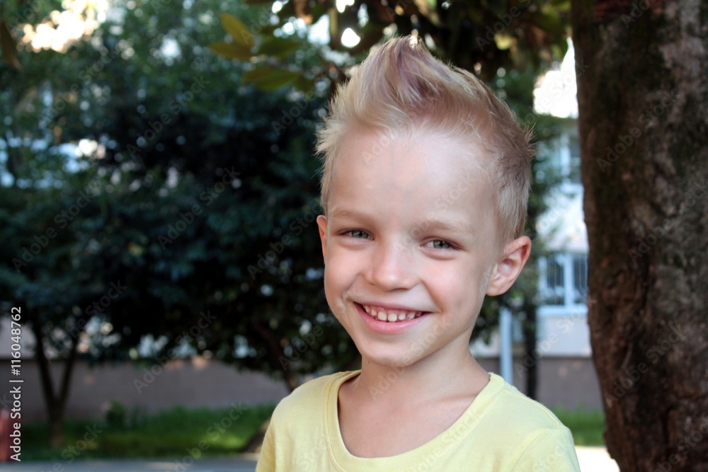 White european young boy smiling and looking directly at the camera. Gender-neutral haircut White european young boy smiling and looking directly at the camera. Gender-neutral haircut
