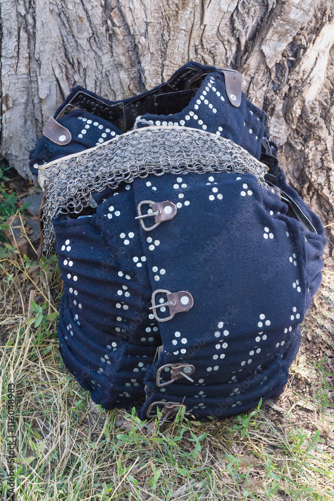 ancient armor of cloth and leather on wood background ancient armor of cloth and leather on wood background