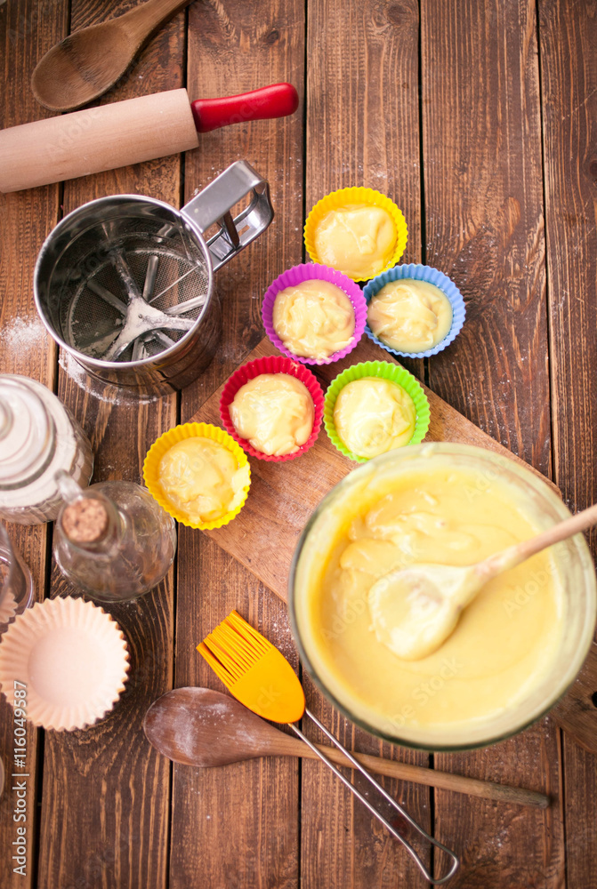 tools and ingredients for making cupcakes on a wooden background. Food texture. Flour, eggs, oil, mix for pastries. Top view