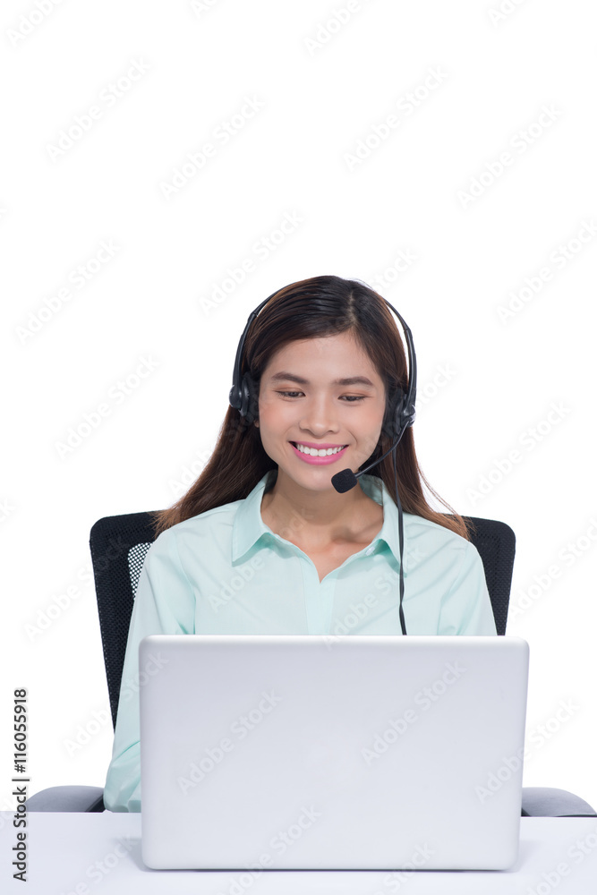 Happy asian young woman sitting and working with laptop using headset in office Happy asian young woman sitting and working with laptop using headset in office