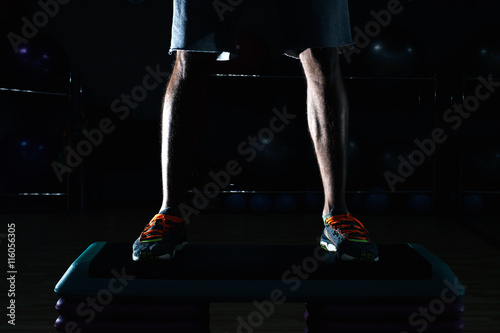 Attractive Young Man Doing Leg Exercises With Machine In Gym photo