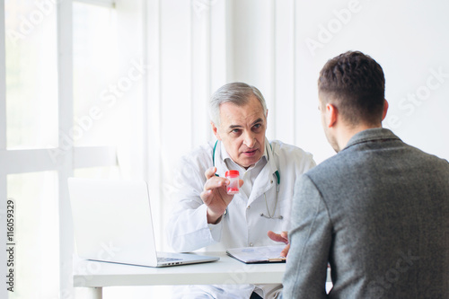 Foto Senior doctor consults young patient