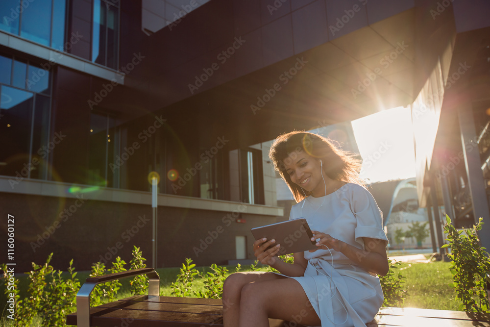 Fototapeta premium Woman making a video call via computer tablet in a city at sunset