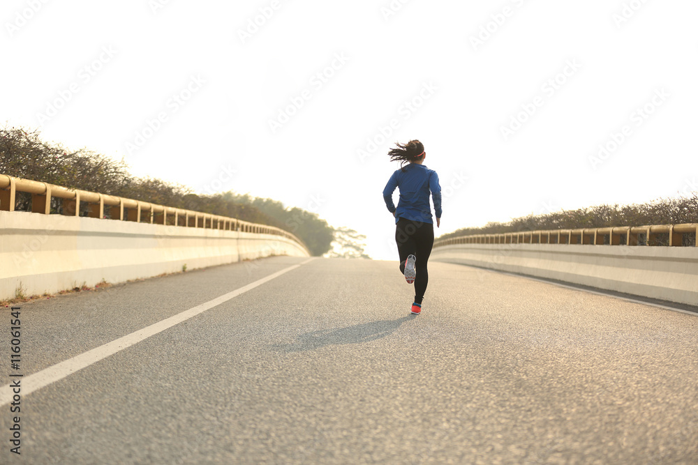 young woman runner athlete running at road