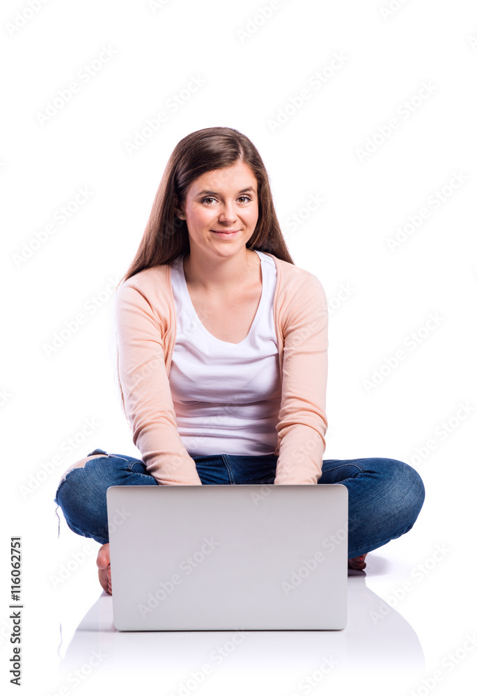 Woman with laptop sitting on the floor, studio shot, isolated Woman with laptop sitting on the floor, studio shot, isolated
