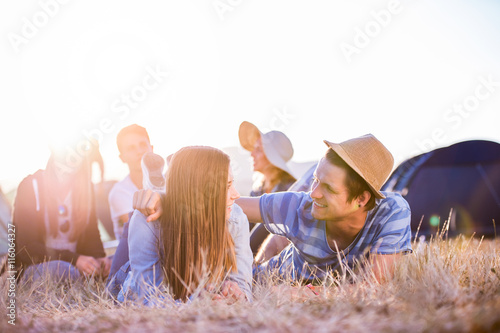 Teenagers lying on the ground in front of tents photo