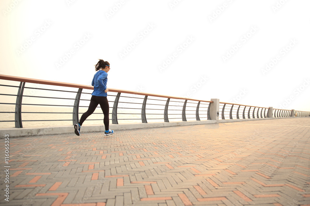 young fitness woman runner running on seaside road young fitness woman runner running on seaside road