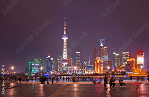 Shanghai, night view of tourists in the Bund and Pudong skyline in the bottom.