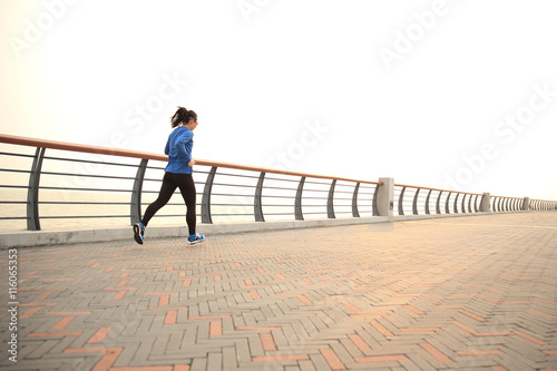 Wallpaper Mural young fitness woman runner running on seaside road Torontodigital.ca
